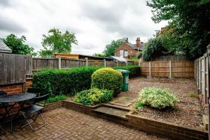 a garden with a table and chairs and a fence at Spacious Central Nottingham House in Nottingham