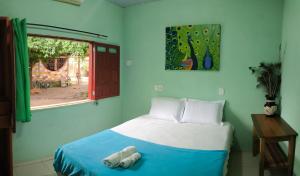 a bedroom with a bed with two towels on it at Caju Hostel in Alter do Chao