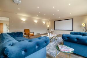 a living room with blue couches and a screen at 2 Bed in Heveningham oc-w29034 in Heveningham