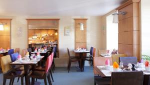 a dining room with tables and chairs in a restaurant at Hôtel Londres et New York - Teritoria in Paris