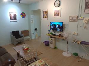 a living room with a couch and a tv and a table at Kluang Countryside Scenery NO LIFT SECOND FLOOR#NETFLIX#RETRO GAME in Kluang