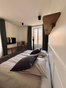 a bedroom with a large bed with pillows on it at MAISON BO TERRA - Chambres et table d'hôtes - Massif des Écrins in Valbonnais +28 photos