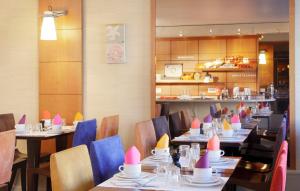 a restaurant with tables with pink and purple hats on them at Hôtel Londres et New York - Teritoria in Paris