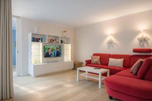 a living room with a red couch and a tv at Ferienwohnung Meeresrauschen in Norderney