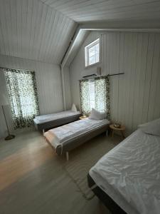 a bedroom with two beds and two windows at Mormors hus in Jörlanda