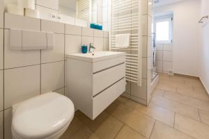 a white bathroom with a toilet and a sink at Villa Marga Ferienwohnung Jenner in Schönau am Königssee +20 photos