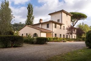 a large white house with trees and a gravel driveway at Villa Valle, Villa Saletta Wine Estate in Forcoli