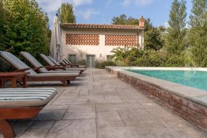 a patio with chairs and a swimming pool at Villa Valle, Villa Saletta Wine Estate in Forcoli