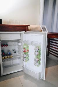 an open refrigerator filled with lots of food and drinks at Pousada do Dione in Delfinópolis