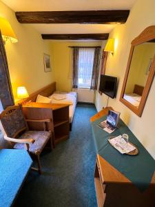 a hotel room with a bedroom with a bed and a desk at Gasthaus Kupfer in Stolberg