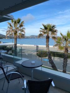 a balcony with a table and palm trees and the ocean at Hôtel La Plage in Sainte-Maxime +26 photos