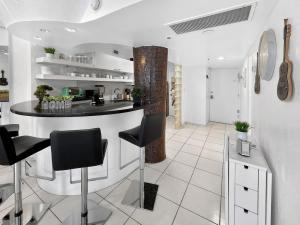 a kitchen with a black counter and black chairs at Miami Beach Studio with shared Heated Pool & Gym in Miami Beach
