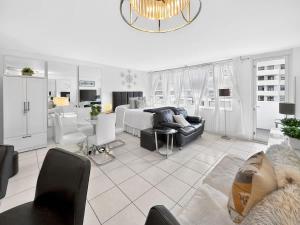 a bedroom with a bed and a living room with a couch at Miami Beach Studio with shared Heated Pool & Gym in Miami Beach