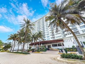 a large building with palm trees in front of it at Miami Beach Studio with shared Heated Pool & Gym in Miami Beach