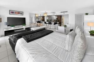 a bedroom with a large white bed and a living room at Miami Beach Studio with shared Heated Pool & Gym in Miami Beach +17 photos