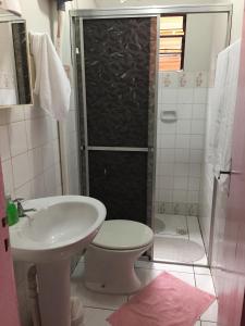 uma casa de banho com um chuveiro, um WC e um lavatório. em Casa Férias Foz em Foz do Iguaçu