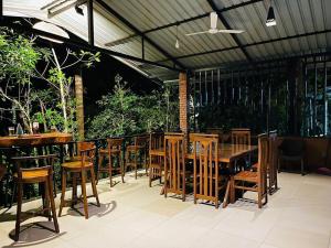 a restaurant with a wooden table and chairs at Niwana Resort in Ratnapura