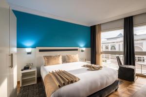 ein Schlafzimmer mit einem großen Bett und einer blauen Wand in der Unterkunft Hotel Le Musée in Rabat + 181 Fotos