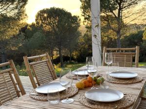 a wooden table with plates and wine glasses on it at Cabana in Sesimbra