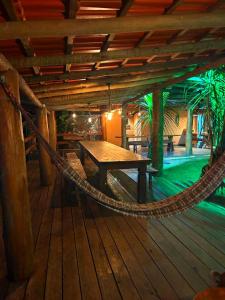 a hammock on a boat with a table and a pool at Pousada Chales da Canastra in Vargem Bonita