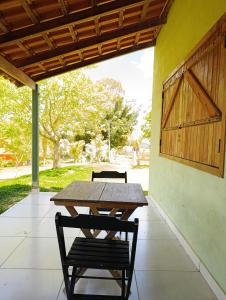 a wooden table and two chairs on a patio at Pousada Chales da Canastra in Vargem Bonita