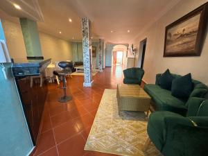 a living room with green chairs and a piano at Villa L'initiale in Oualidia