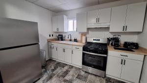 a kitchen with white cabinets and a stove top oven at Oswego 2BR Ground-Floor Apt Near SUNY, Walk to Downtown & Lake Ontario in Oswego