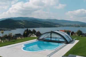 a swimming pool with a dome house on top of a hill at VILLA nad JEZIOREM in Mucharz