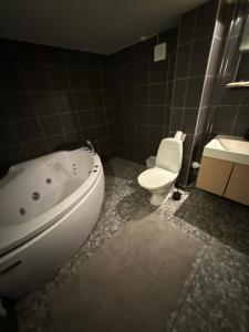 a bathroom with a white tub and a toilet at Mormors hus in Jörlanda
