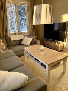 a living room with a couch and a coffee table at Snöbergets Arctic Cabin in Luleå