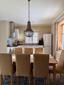 a kitchen with a table and chairs and a refrigerator at Snöbergets Arctic Cabin in Luleå +6 photos