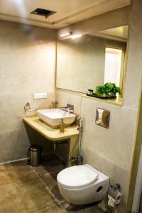 a bathroom with a toilet and a sink and a mirror at All seasons boutique rooms in Pune +28 photos