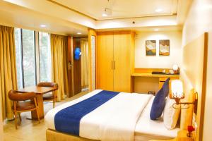 a bedroom with a bed and a desk and a table at All seasons boutique rooms in Pune