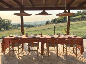 a wooden table with chairs and a table with a view of a field at Agriturismo Scala - Eco Boutique B&B in Le Marche in Potenza Picena