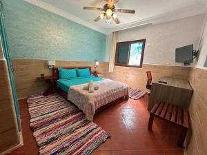 a bedroom with a blue bed and a rug at Villa L'initiale in Oualidia +15 photos