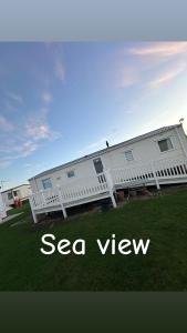 a white house with a seder window on the side of it at Seaside views in North Seaton