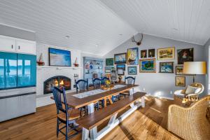 a dining room with a table and chairs and a fireplace at Shaws Cove Beachouse in Gig Harbor