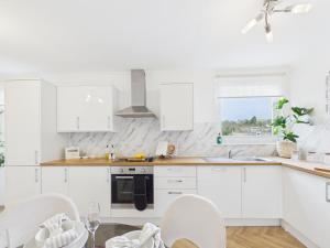 a white kitchen with white cabinets and white appliances at The Bridge View Apartment in Hawick