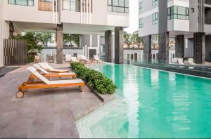 a swimming pool with lounge chairs and a building at High Floor Sea View at The Base Pattaya by 888 in Pattaya
