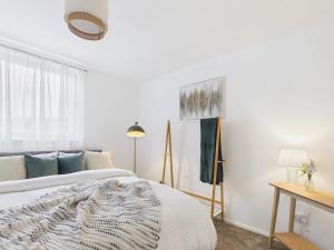 a white bedroom with a bed and a window at The Bridge View Apartment in Hawick