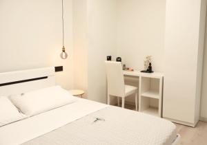 a white bedroom with a bed and a desk at Tower Suite Trento in Trento