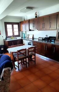 a kitchen with a table and chairs in it at Casa da Avó Maria in Podence