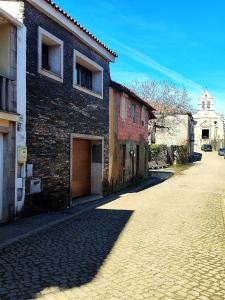 a brick building on a cobblestone street at Casa da Avó Maria in Podence