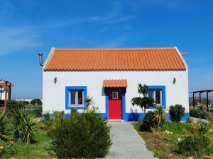 a small white house with a red door at Serras d'Sal in Alcochete