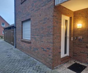 a brick building with a door on the side of it at Ferienwohnung Seesternchen am Deich2 C46 in Norden