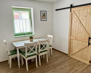 a dining room with a table and chairs and a sliding door at Fenyőudvar Vendégház Mocsa in Mocsa +16 photos