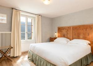 a bedroom with a large white bed and a window at QC Hotel Bagni Vecchi in Bormio +52 photos