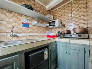 a kitchen with a sink and a stove at CAMERHOME Lycée Cité des palmiers in Douala +55 photos
