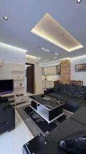 a living room with a couch and a tv at Shtepi ditore elbasan in Elbasan
