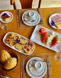 a wooden table with plates of food on it at Pousada Corais do Bitingui in Japaratinga